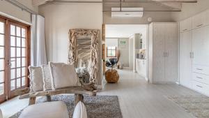 a living room with a mirror and a chair at The Glen Boutique Hotel & Spa in Cape Town