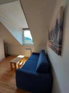 a living room with a blue couch and a table at La Chouette in Gérardmer