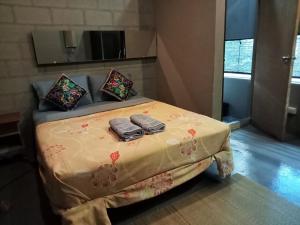 Una cama en una habitación con dos toallas. en Baba pim villa en Chiang Mai