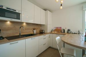 cocina con armarios blancos y encimera de madera en La Douce Folie - Apartment for 4 to 5 people in Sevrier, en Sévrier