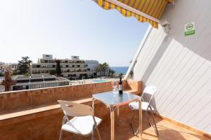 einen Tisch und Stühle auf einem Balkon mit Meerblick in der Unterkunft Listen the SILENCE - 355 in Arona
