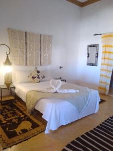 ein Schlafzimmer mit einem Bett mit einem Schwan darauf in der Unterkunft L'oasis Du Bonheur in Aït-Ben-Haddou