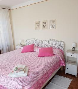 コモにあるGuest House Villa Cortiのピンクの枕2つとピンクのベッド1台が備わるベッドルーム1室が備わります。