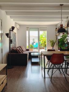 a living room with a couch and a table at Incredible 2BR Penthouse with Urban Rooftop Garden in Barcelona