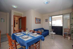een woonkamer met een tafel met een blauwe tafeldoek bij Marzamemi Vacanze in Marzamemi