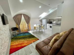 a living room with a couch and a colorful rug at Premier City Apart Hotel Chisinau in Chişinău