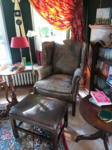 a living room with a chair and a table at Gästehaus "Villa am Eggenbach" Familie Heiss in Eggenbach