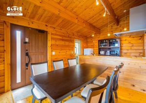 a dining room with a large wooden table and chairs at 石田ヴィレッジ 満天の星空が見えるログハウスを貸し切り 宮古空港から8分 無料駐車場付 長期滞在可 in Miyako Island +31 photos