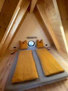 two beds in the attic with a window at Ferienturm zur ehemal. Umspannstation Poppenroth in Bad Kissingen