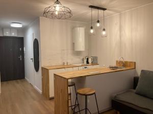 a kitchen with a counter and a bar with stools at Yellow Stone Apartment in Szczecin