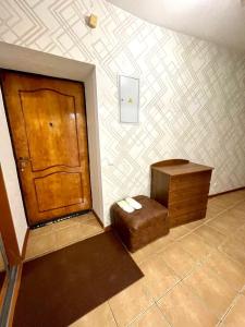 a room with a door and a stool and a table at Апартаменты на ул.Мира in Perm
