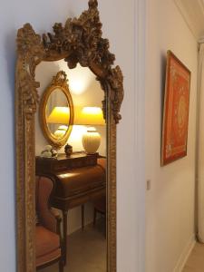 a mirror on a table with a lamp on it at CHARMING FLAT -PRIVATE AVENUE - 16 TH in Paris