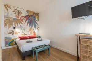 1 dormitorio con 1 cama y un mural en la pared en Gabylou, en Burdeos