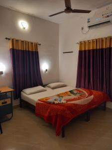 a bedroom with two beds and purple curtains at White Shore Beach Homestay in Alleppey