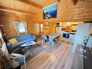 a living room with a blue couch and a kitchen at Blockbohlenhaus Plau am See in Plau am See
