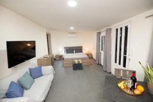 a living room with a couch and a bed at Lithines Villa go green in Dhafnés