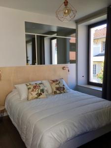 1 dormitorio con 1 cama grande y espejo grande en chez Nous en Vittel