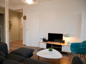 a living room with a couch and a tv at chez Nous in Vittel