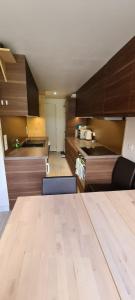 a kitchen with wooden cabinets and a wooden table at Centre Station: Altineige Cosy Appart pour 4 in Val Thorens