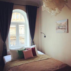 a bedroom with a bed with a window at Best View Kazanskaya in Saint Petersburg