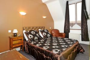 a bedroom with a bed and a desk and a window at Hotel La Tour in Sully-sur-Loire