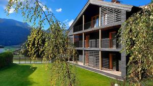 un gran edificio con ventanas y un patio verde en Kranzmuehle - Ankommen am Achensee en Achenkirch