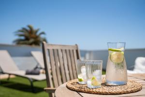 a table with a vase and a glass of water and lemons at Chada Morro Jable in Morro del Jable