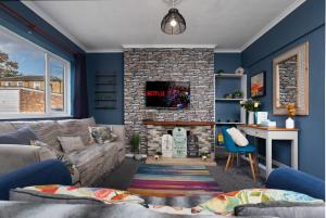 a living room with a fireplace and blue walls at Perfect for Contractors - Canterbury - Free parking - Ultra WiFi in Canterbury