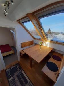 een kleine kamer met een tafel en een groot raam bij Ferienwohnung-Rotmoosblick-direkt-am-Rande-unberuehrter-Natur in Isny im Allgäu