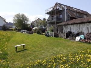 eine Bank im Gras vor einem Haus in der Unterkunft Ferienwohnung Rotmoosblick direkt am Rande unberührter Natur in Isny im Allgäu