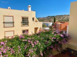 a building with pink flowers in front of it at Nascer do Sol in Luz