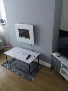 a living room with a coffee table and a tv at Modern property close to Aintree Hospital & Motorways in West Derby