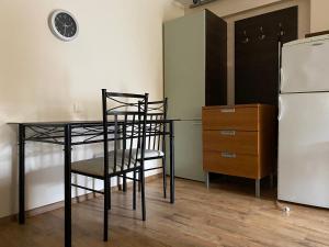 a kitchen with a table and chairs and a refrigerator at Kalnas II apartaments in Juodkrantė +3 photos