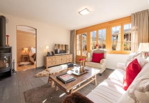 a living room with a white couch and a table at Les Residences Waldbort in Wengen