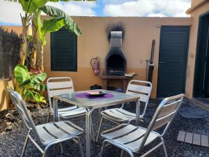 a patio with a table and chairs and a stove at Cuyagua in Corralejo