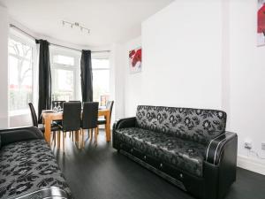 a living room with a black couch and a table at Shared Short Term South Manchester Accommodation in Manchester