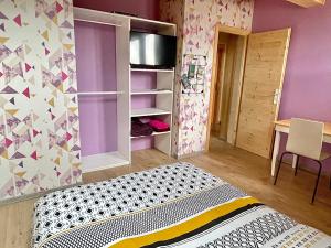 een slaapkamer met paarse muren en een bed in een kamer bij Chambre privée au pied des pistes - Chambre chez l'habitant - ChaletNelda com in Lamoura