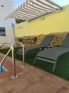 a picnic table and a bench under an umbrella at LA FUENTE 2 in El Gastor