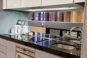 una cocina con fregadero y una barra con libros en 1007-Stunning Studio apt with incredible Joburg views, en Johannesburgo