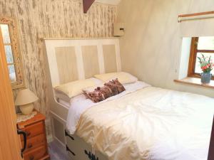 a bedroom with a white bed with pillows on it at Farm accommodation - The Lizard Peninsula, Cornwall in Helston