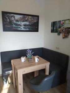 a wooden table with a chair and a table with flowers on it at Ferienwohnung Radebeul Self Check-in in Radebeul +12 photos