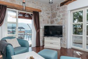 a living room with a tv and a blue chair at Villa Hana in Motovun