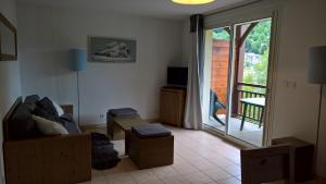 uma sala de estar com um sofá e uma porta de vidro deslizante em Le Belvédère em Saint-Mamet