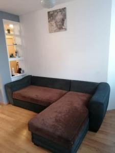 um sofá com um banquinho num quarto em Dadla em Marselha