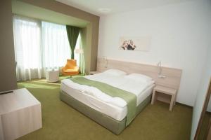 a bedroom with a large bed and a chair at Hotel Armatti in Braşov +37 photos