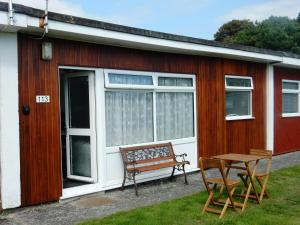 a wooden house with a bench and a table at Dartmouth Chalet Holidays in Dartmouth
