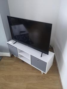 a flat screen tv sitting on a white entertainment center at Modern property close to Aintree Hospital & Motorways in West Derby
