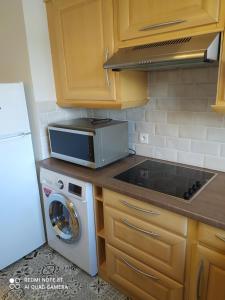 a kitchen with a stove top oven next to a microwave at DEAUVILLE STAR LUXE in Deauville