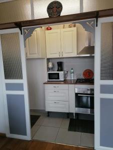 a kitchen with white cabinets and a microwave at Dadla in Marseille