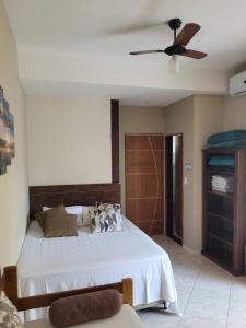 a bedroom with a bed and a ceiling fan at Mares de Camburizinho in Camburi